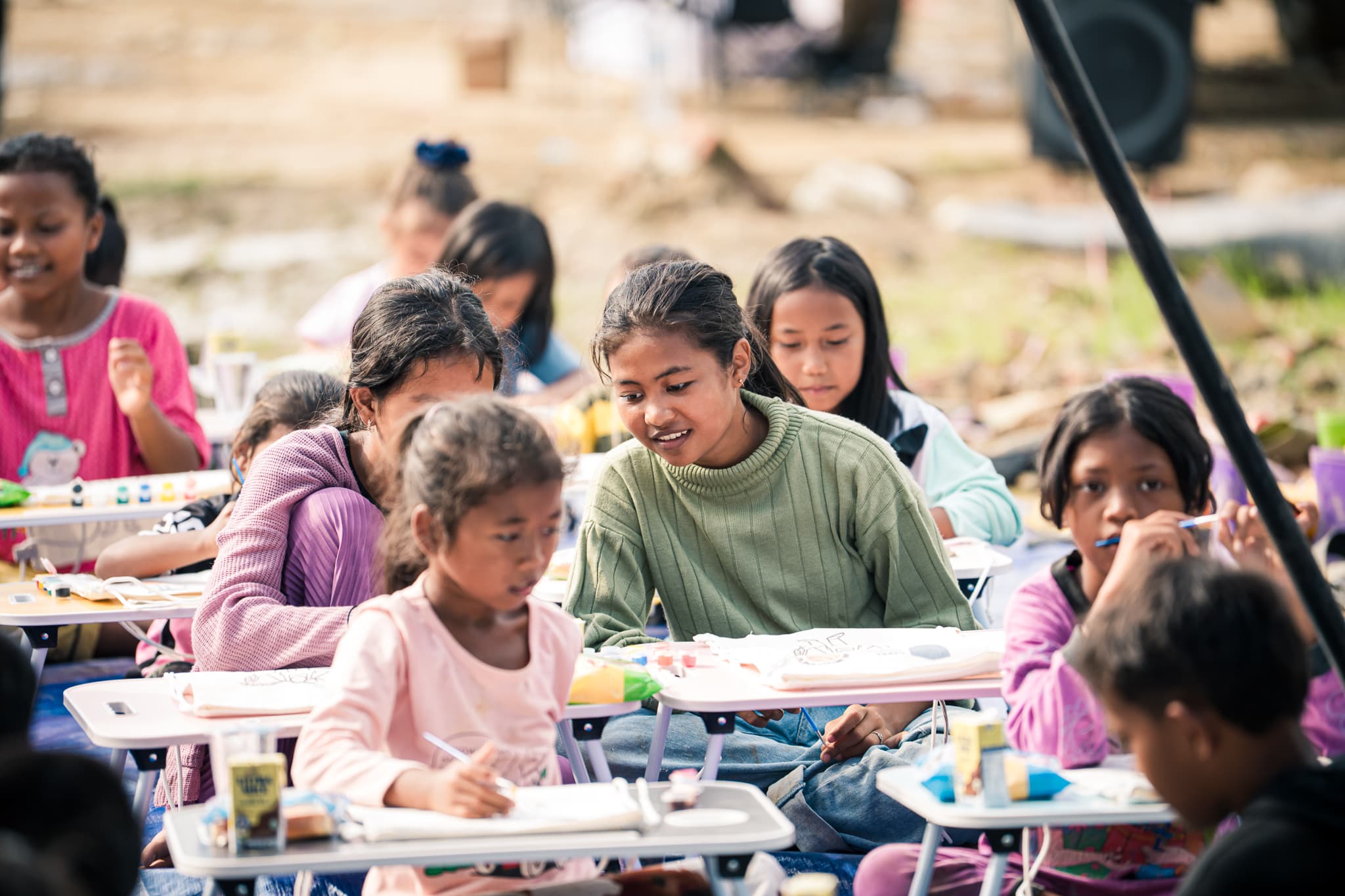 Children focused on learning at desks in a temporary classroom
