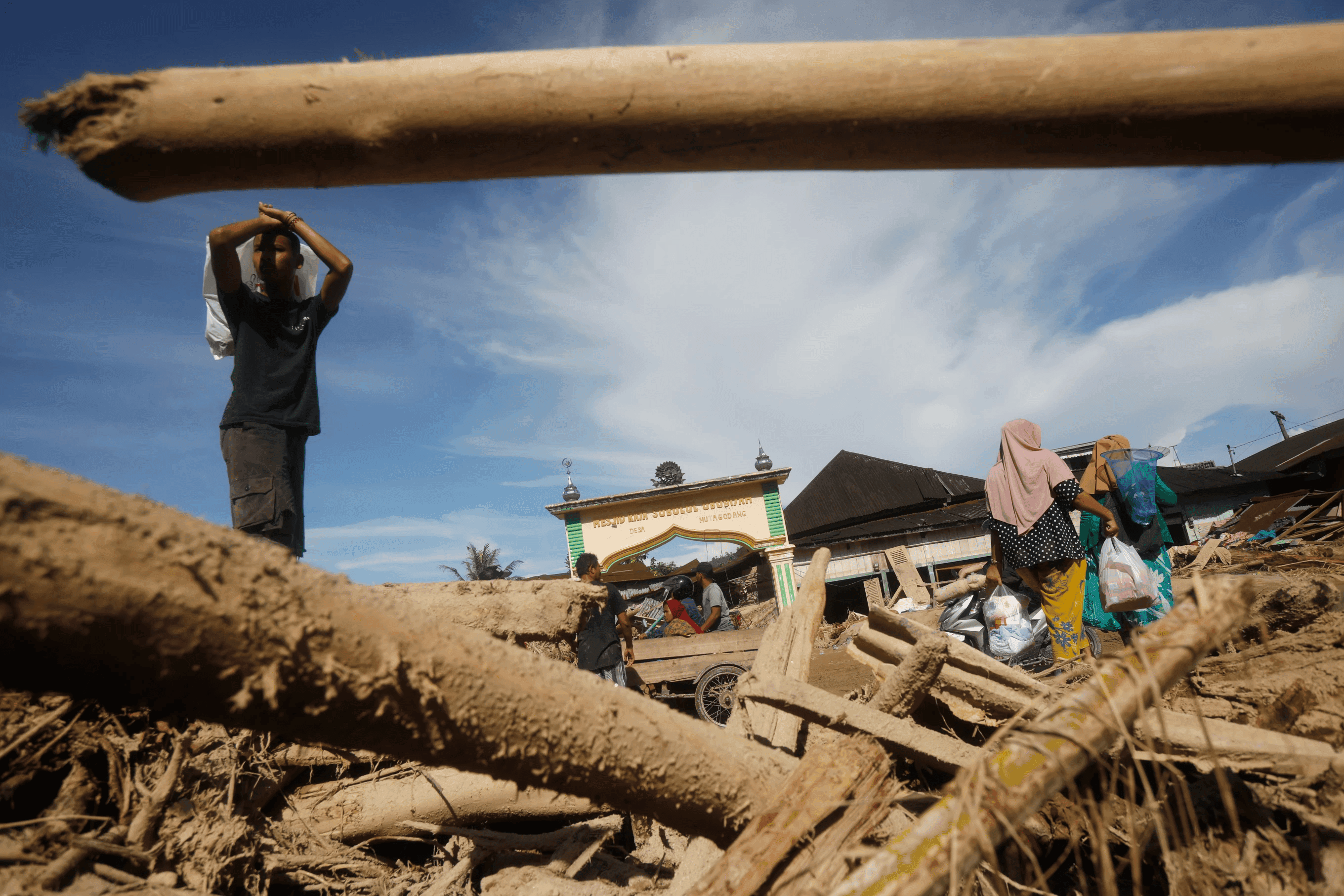 A man stands amid mud and ruins after the floods in Aceh